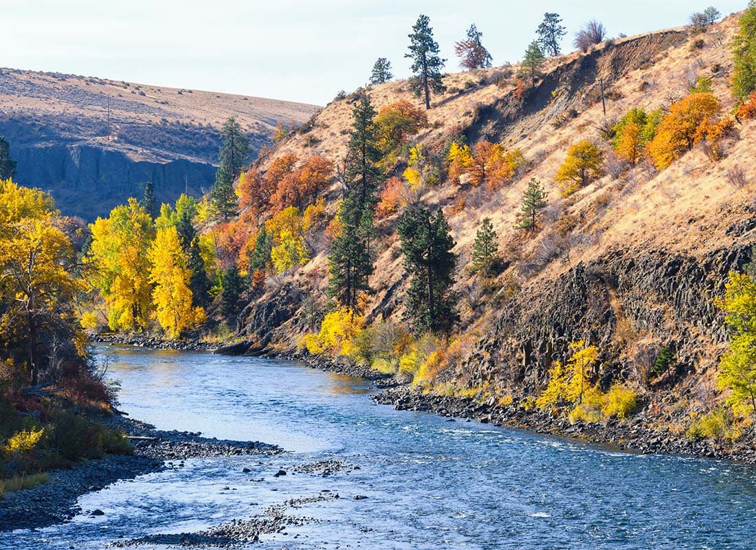 Yakima, WA - View of a River Next to Mountains on a Sunny Day with Colorful Fall Trees in Yakima Washington